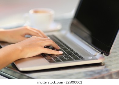 Close Up Of A Woman Hands Working With A Laptop In A Coffee Shop Table