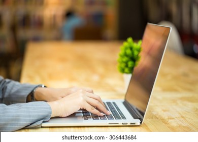 Close Up Of A Woman Hands Working With A Laptop In A Coffee Shop