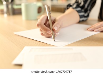 Close up of woman hands writing letter sitting on a desk