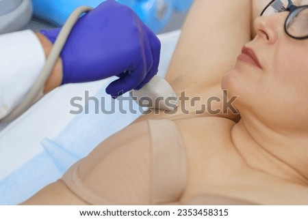 Close up of woman has ultrasound lymph nodes in area under the armpits in clinic. High quality photo