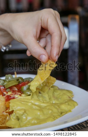 Close up of woman having chili cheese nachos her lunch