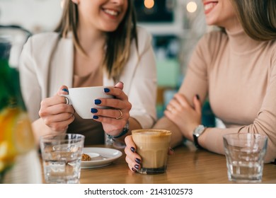 close up of woman holding cup of coffee in cafeteria - Powered by Shutterstock