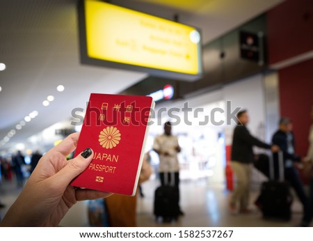 Close up of woman holding a Japan passport over a blurred airport background. Digital composite.Japan and Singapore have the world s most powerful passports, according to the Henley passport index
