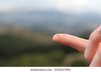Close up of woman holding mustard seed in finger in front of a mountain. Faith parable, trust and belief in God and Jesus Christ, Christian growth, biblical concept. Copy space.