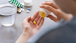 Close Up Woman Holding Pill In Hand With Water. Female Going To Take Tablet From Headache, Painkiller, Medication Drinking Clear Water From Glass. Healthcare, Medicine, Treatment, Therapy Concept