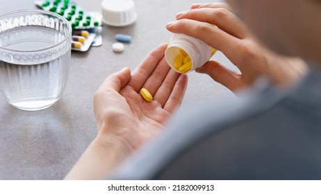 Close up woman holding pill in hand with water. Female going to take tablet from headache, painkiller, medication drinking clear water from glass. Healthcare, medicine, treatment, therapy concept - Shutterstock ID 2182009913