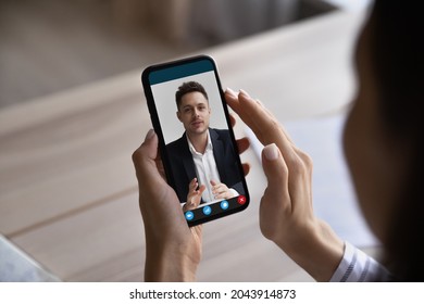 Close up woman holding smartphone in hands, making video call to colleague, businesswoman chatting online by phone webcam, engaged in virtual event, conference, watching webinar or training - Powered by Shutterstock