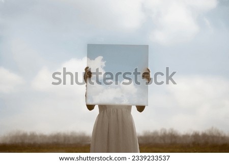 close up of a woman holding a surreal painting of the sky in front of her face, abstract concept