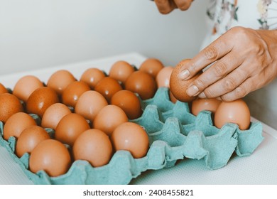 Close up of a woman holding a tray of free-range red eggs. The egg has nutrients with antioxidant action such as carotenoids, vitamin A and E, folic acid, zinc, magnesium and selenium - Powered by Shutterstock