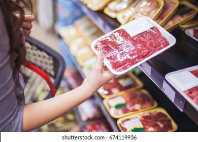 Close Up Of Woman Holding Wrapped Meat In Grocery Store