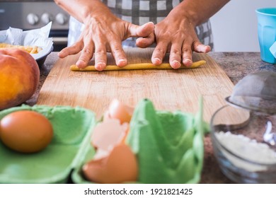 Close up of woman at home preparing and cooking hand made pasta on the table - concept of work indoor house activity for wife or single female - healthy food nutrition cake pie lunch
