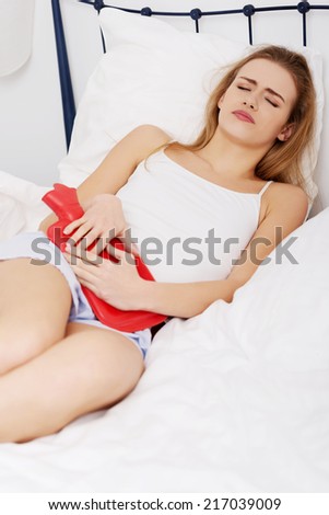 Close up of woman with hot water bottle in bed.