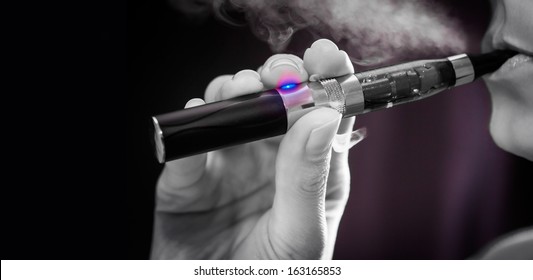 Close up of a woman inhaling from an electronic cigarette 