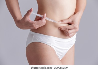 close up of woman inject drugs to prepare for IVF treatment isolated on gray background, model is a asian beauty - Shutterstock ID 309089399