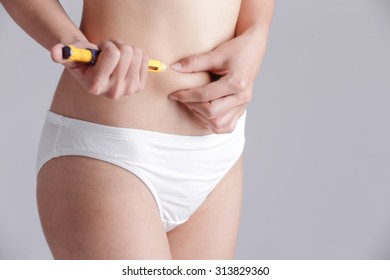 Close Up Of Woman Inject Drugs To Prepare For IVF Treatment Isolated On Gray Background, Model Is A Asian Beauty