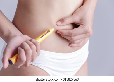 Close Up Of Woman Inject Drugs To Prepare For IVF Treatment Isolated On Gray Background, Model Is A Asian Beauty