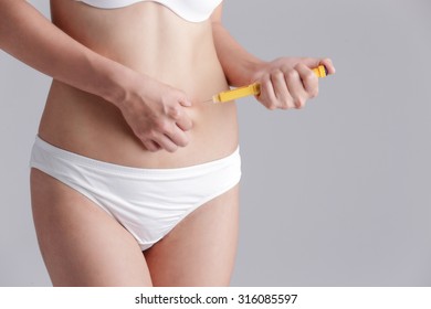 Close Up Of Woman Inject Drugs To Prepare For IVF Treatment Isolated On Gray Background, Model Is A Asian Beauty