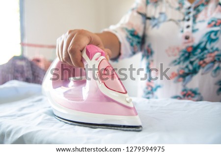 Close up of woman ironing clothes on ironing board