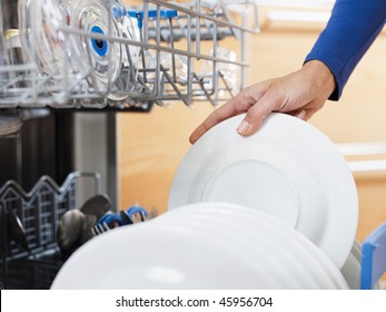 Close Up Of Woman In Kitchen Using Dishwasher