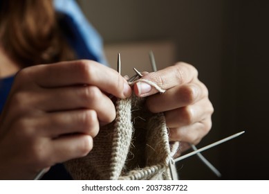Close up of woman knitting socks. Hands knit with needles at home - Shutterstock ID 2037387722