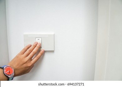 close up woman left hand with cute watch turn off the office light switch for energy savings