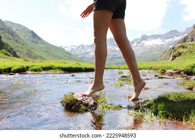 Close up of a woman legs bareffot crossing river in the mountain - Shutterstock ID 2225948593