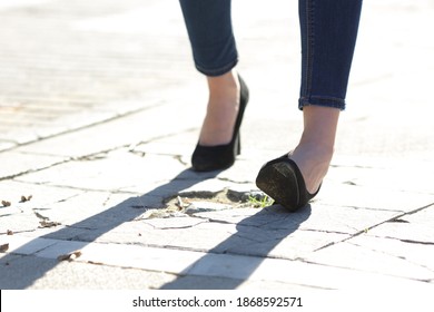 Close up of a woman legs with high heels spraining ankle while walking in the street
