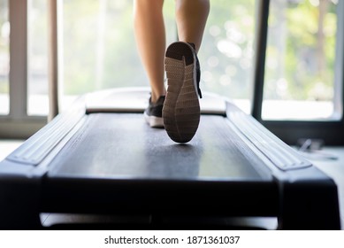El acercamiento de las piernas de las mujeres con zapatillas de corredor es correr en máquina de correr o cinta de correr en gimnasio, concepto de actividad saludable y ejercicio.