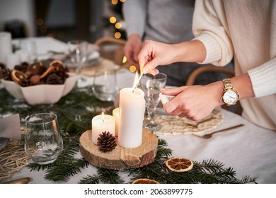 Close Up Woman Lights A Candle In Christmas Eve                            