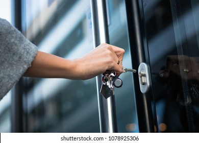 Close Up Of Woman Locking Entrance Door With A Key. Person Using Key And Unlocking Apartment Door.