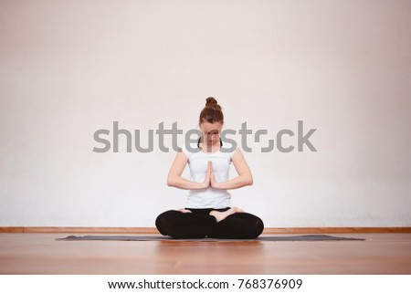 Close up woman meditates while practicing yoga in training hall or home.
