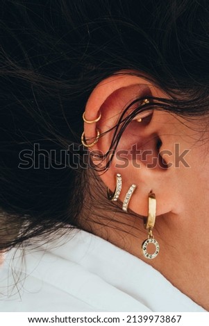 Close up of the woman with multiple piercings on the ear