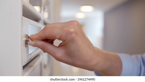 Close Up Of Woman Opening Postbox And Taking Mail. Cropped Shot Of Female Unlocking Mailbox And Taking Correspondence In Apartment Building Lobby