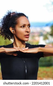 Close Up Woman Outdoors With Earphones And Curly Hair Hands On Chest Sports Outfit