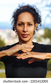 Close Up Woman Outdoors With Earphones And Curly Hair Hands On Chest Sports Outfit