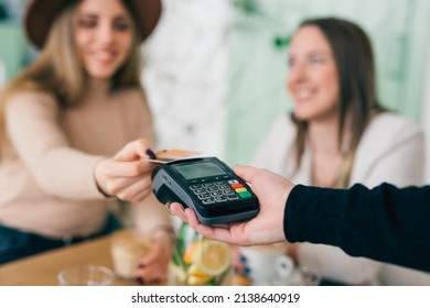 Close Up Of Woman Paying Contactless With Credit Card In Restaurant