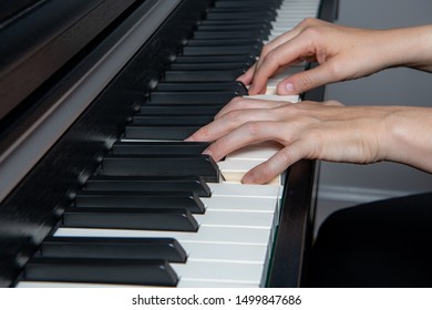 Close Up Of A Woman Playing The Piano. Left Hand Plays A Power Chord And Right Hand Plays The Melody.