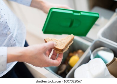 Close Of Woman Putting Food Waste Into Recycling Bin In Kitchen