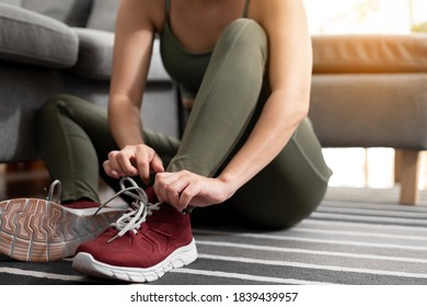 Close up woman putting on her sport shoes at home - Powered by Shutterstock