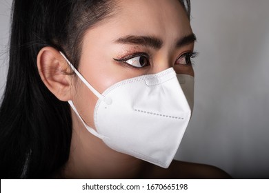 Close up of a woman putting on a respirator N95 mask to protect from airborne respiratory diseases as the flu covid-19 coronavirus ebola PM2.5 dust and smog, Safety virus infection concept