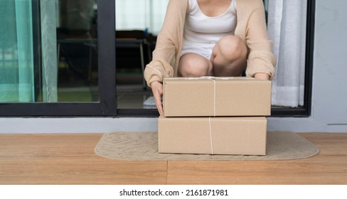 Close Up Woman Receiving Goods In Front Of The House. Delivered Parcel On Door Mat Near Entrance