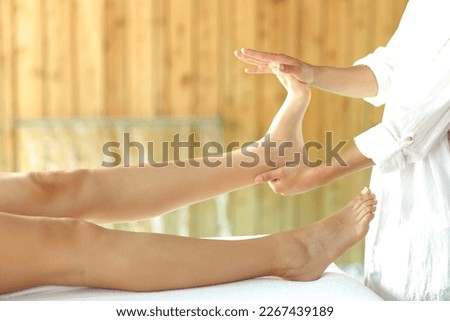 Close up of a woman receiving a reflexotherapy massage on foot in spa