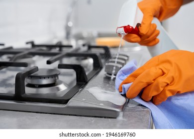 Close Up Of Woman In Rubber Disposable Gloves Cleaning Cooker With Detergent. Concept Of Process House Cleaning.