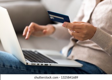 Close up woman shopping, paying by credit card, buying goods or ordering online, using laptop, login internet bank service, typing on keyboard, checking balance, sitting on sofa at home - Powered by Shutterstock - Get 15% off with code: PIKWIZARD15