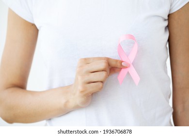 Close up of woman showing pink ribbon symbolizing breast cancer - Shutterstock ID 1936706878