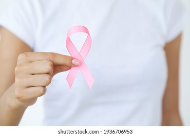 Close up of woman showing pink ribbon symbolizing breast cancer - Shutterstock ID 1936706953