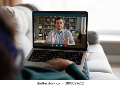 Close up of woman sit on couch look at laptop screen have webcam digital online conference with male colleague. Female use computer talk speak on video call on computer. Communication concept.