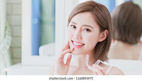close up of woman smile happily and take invisible brace - Shutterstock ID 1160893975