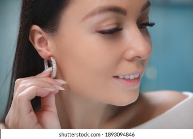 Close up of a woman smiling, wearing hoop diamond earring