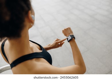 Close up of woman in sportswear looking on smartwatch after running. Outdoor sports in the morning - Powered by Shutterstock